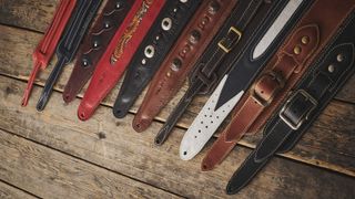 A collection of guitar straps on a wooden floor