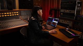 Person using an Apple MacBook Pro in a large studio