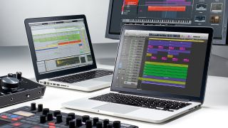 Two laptops for music production with a PC monitor, audio interface, and MIDI controller