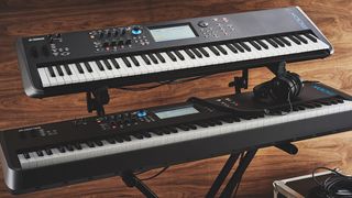 A pair of keyboards on a stand against a wooden wall